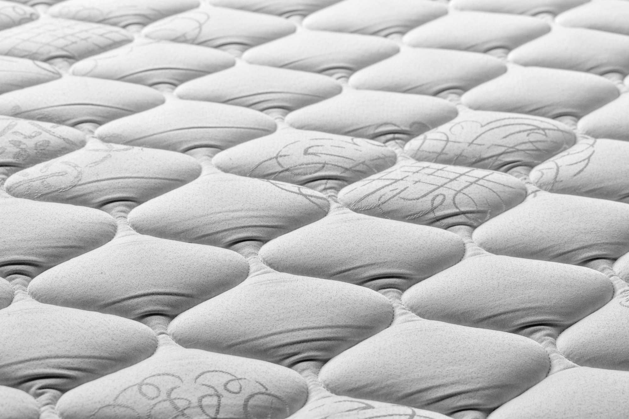 Unsplash Top of an innerspring mattress with solid edge support and soft cushioning for hip and back pain