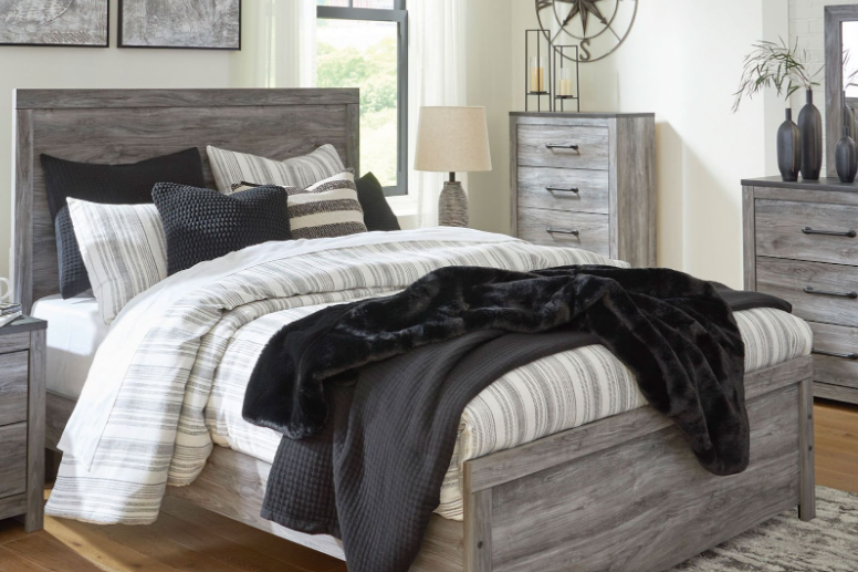 A large bed with thick bedding and a wooden frame