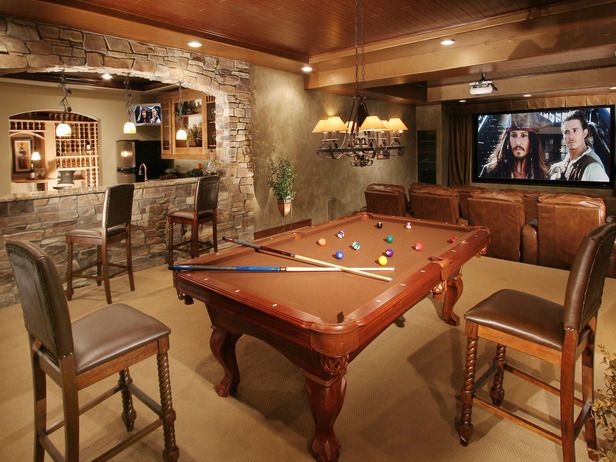 Mountain rustic man cave with stone fireplace and leather sofa