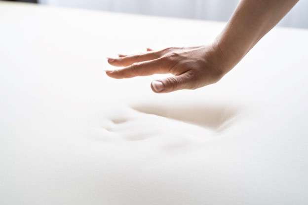 Person leaving a handprint on a memory-foam mattress