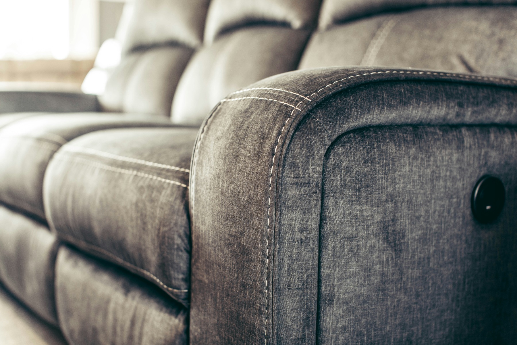 A grey power-operated recliner sofa