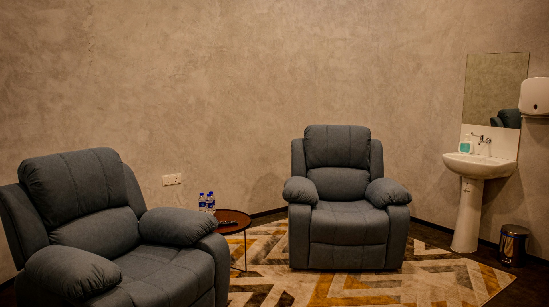 Two grey recliners on either side of a coffee table