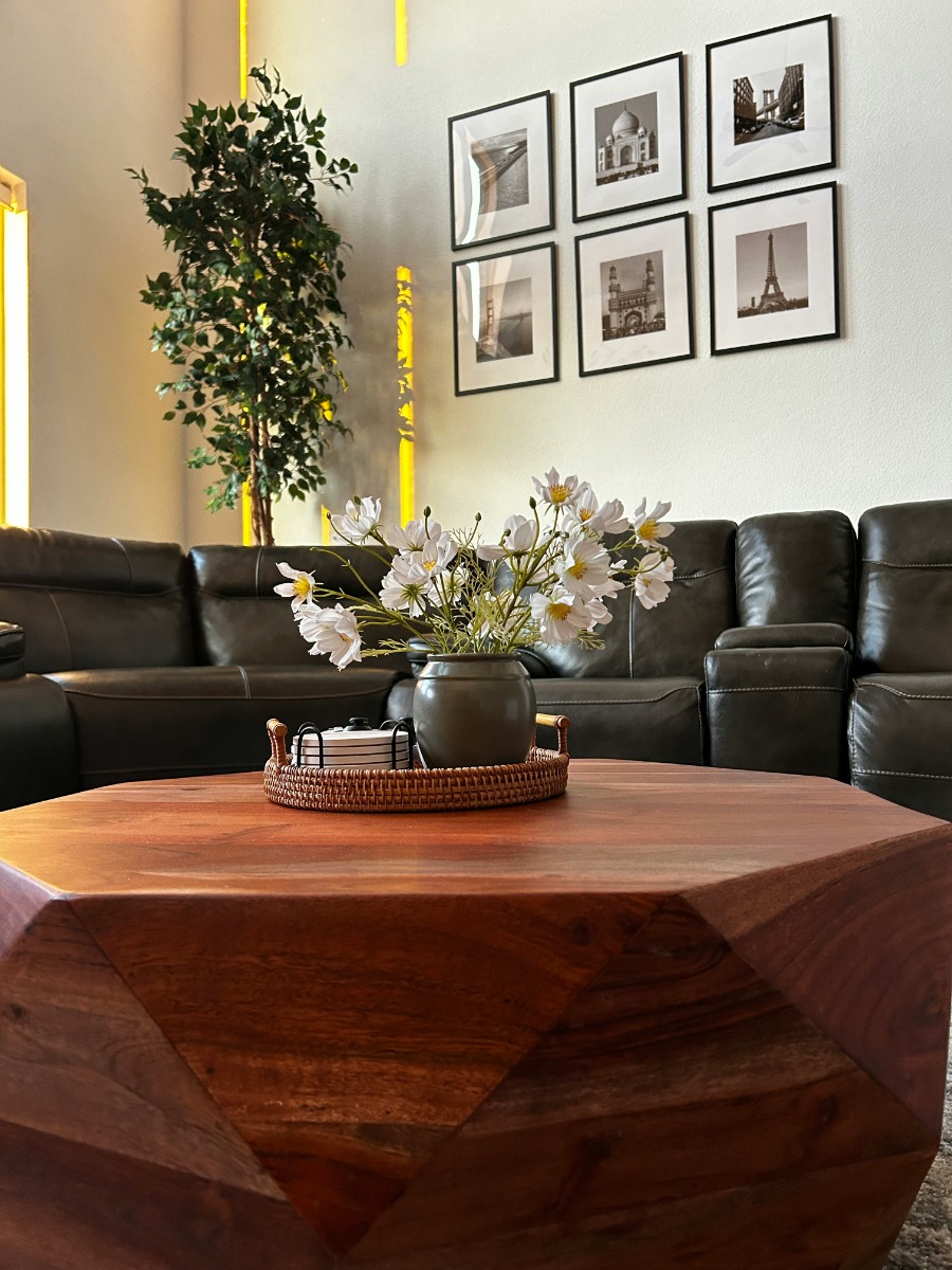 A leather recliner sofa set behind a coffee table with flowers