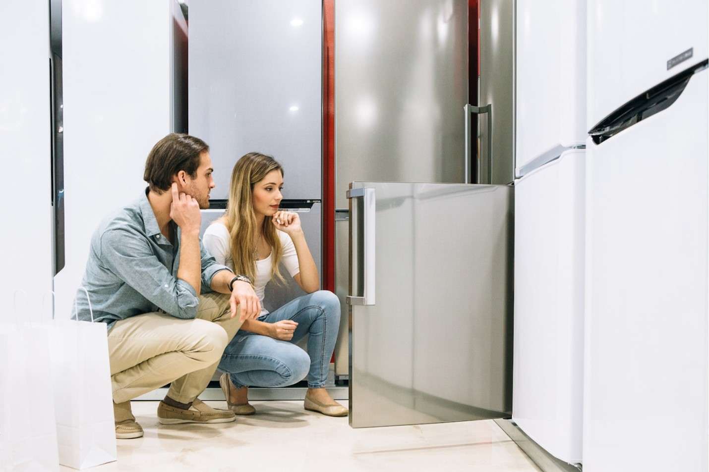 People looking at fridges in an appliance store