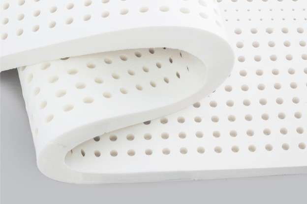 A folded white latex mattress filling commonly used in beds and pillows