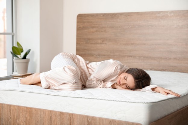 A woman lying peacefully on an uncovered memory foam mattress