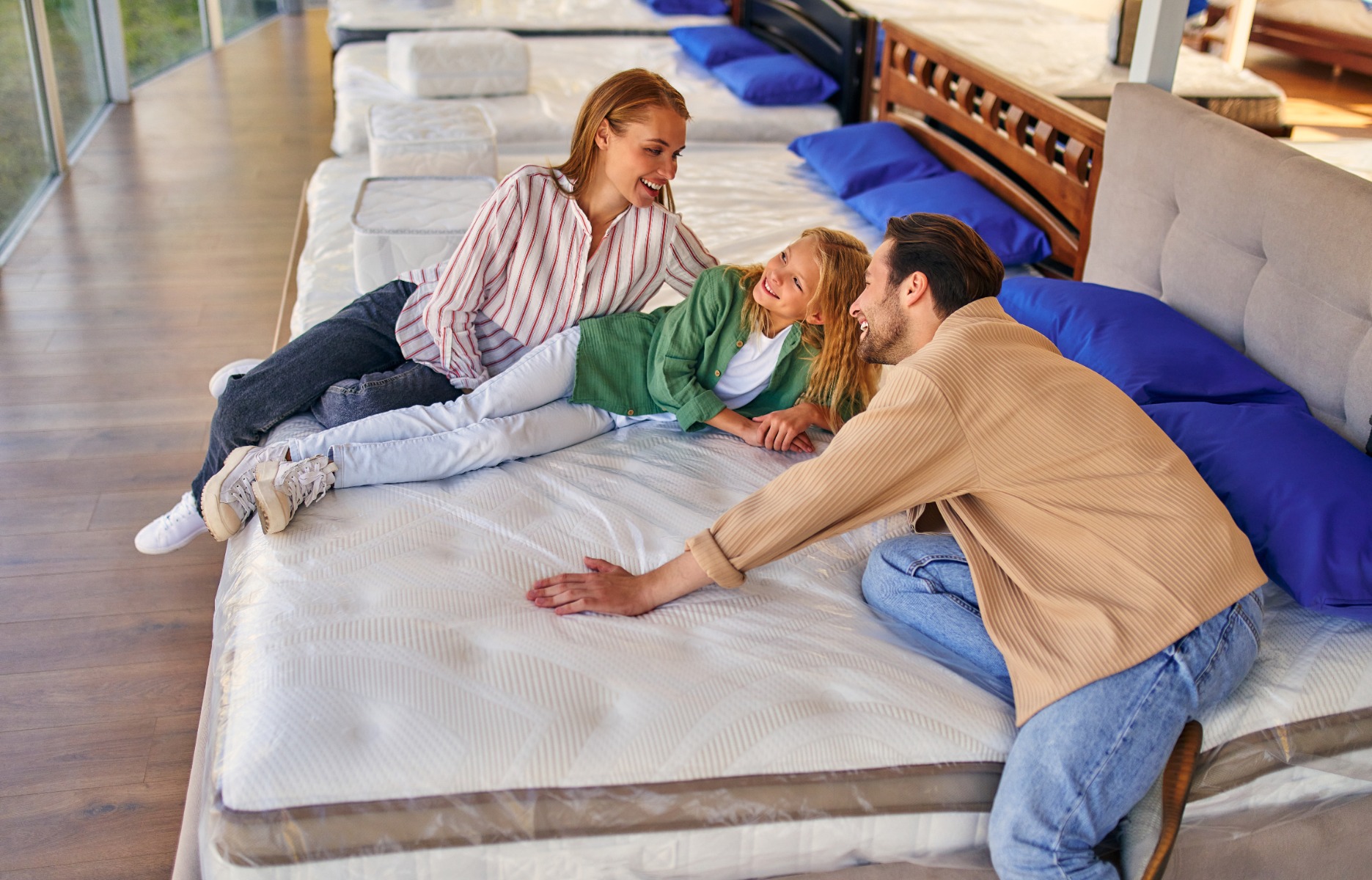 A family testing mattresses with a sales representative