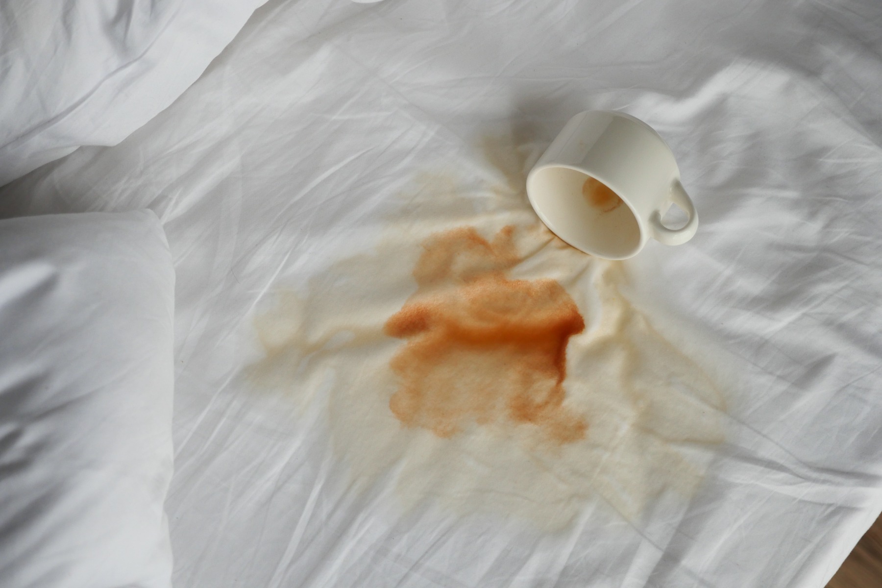 Spilled coffee on white sheets