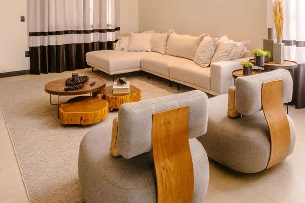 A modern living room with a white sectional sofa and two circular chairs