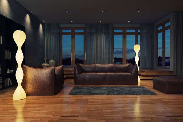 A living room with a leather sofa and tall, wavy floor lamps