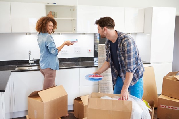 Two people unpacking plates for the kitchen