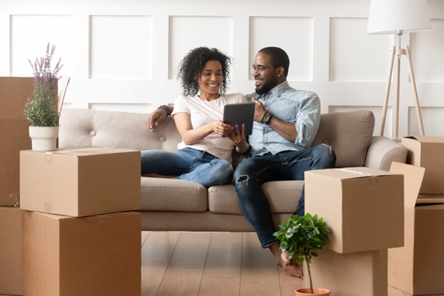 Couple sitting on the sofa with unpacked boxes