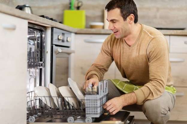 A person loading a dishwasher