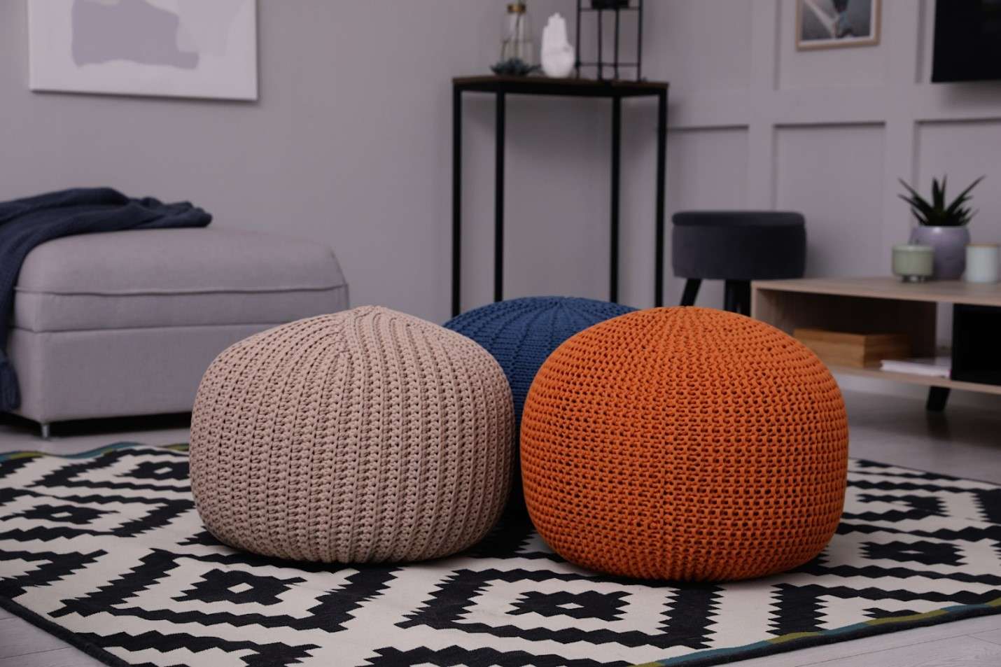 Three poufs on a geometric rug