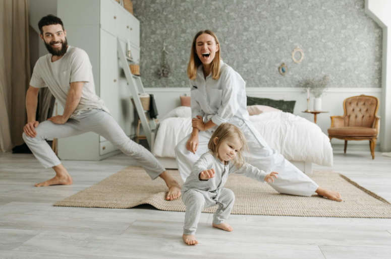 Two parents playing with their baby in the bedroom