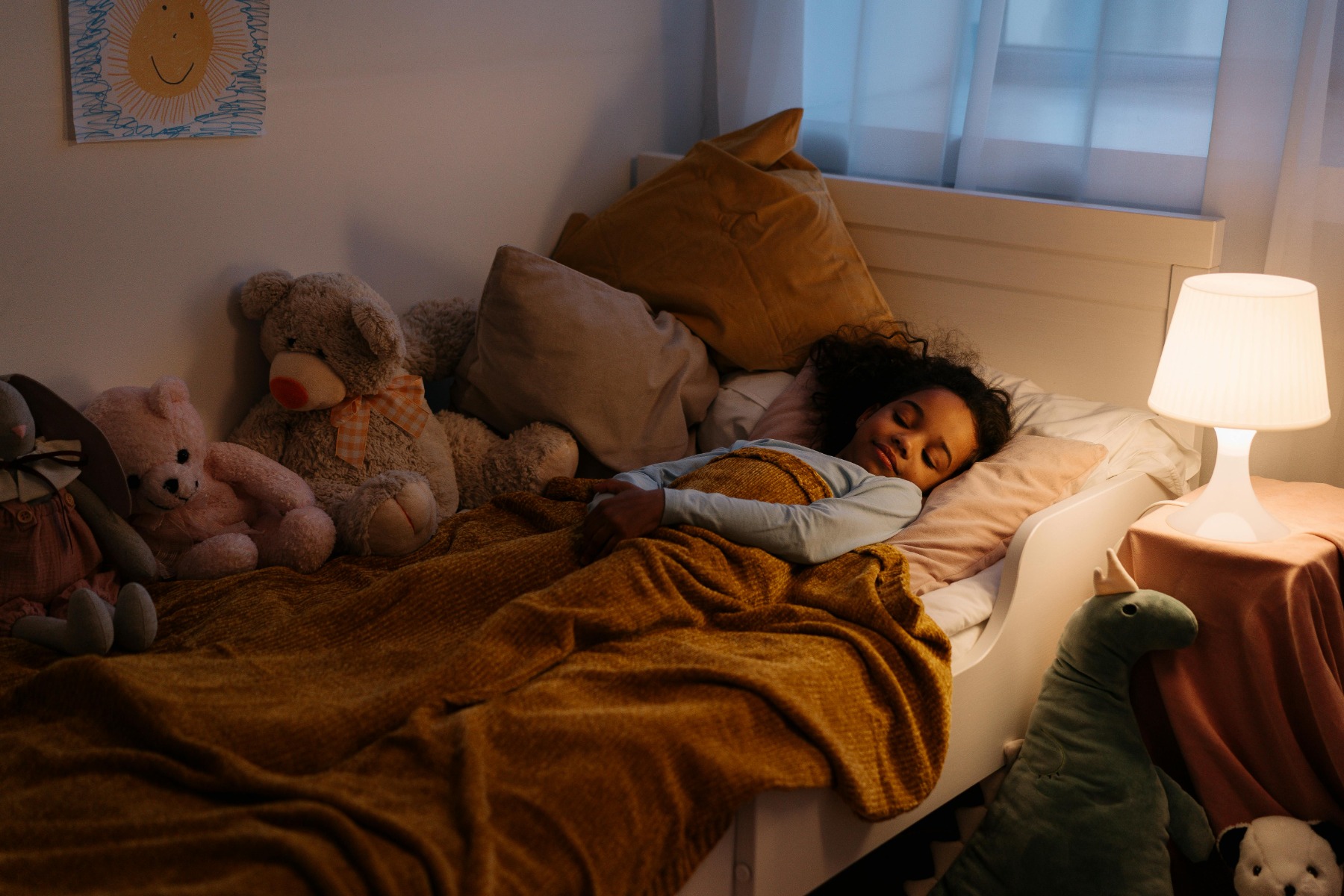 Small girl sleeping in a bed on her own