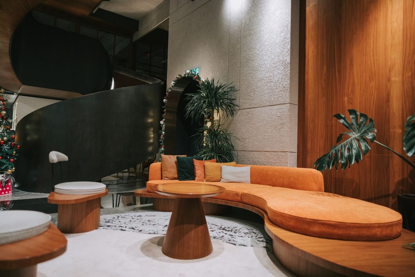 Lounge area with a round orange sofa, coffee table, and seats