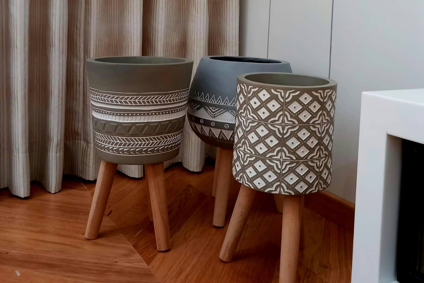 A group of carved clay pots on wooden pegs