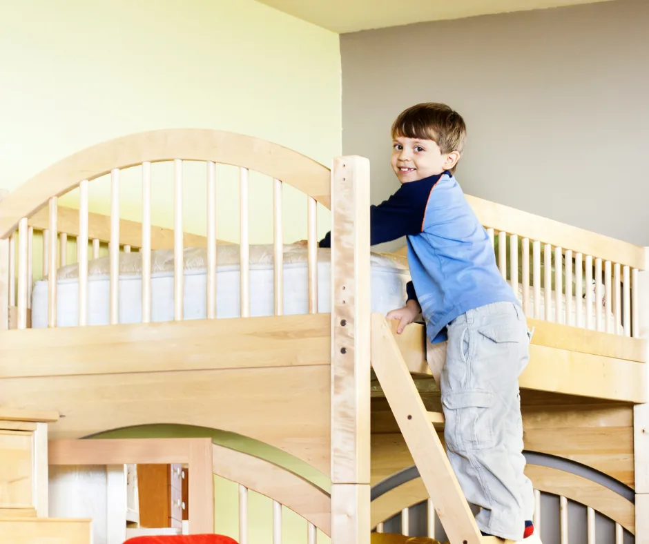 Young boy climbing the top bunk during bedtime